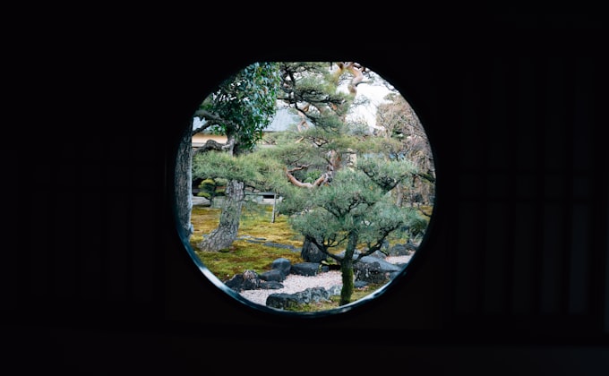 Japanese garden viewed through a circular moon gate window