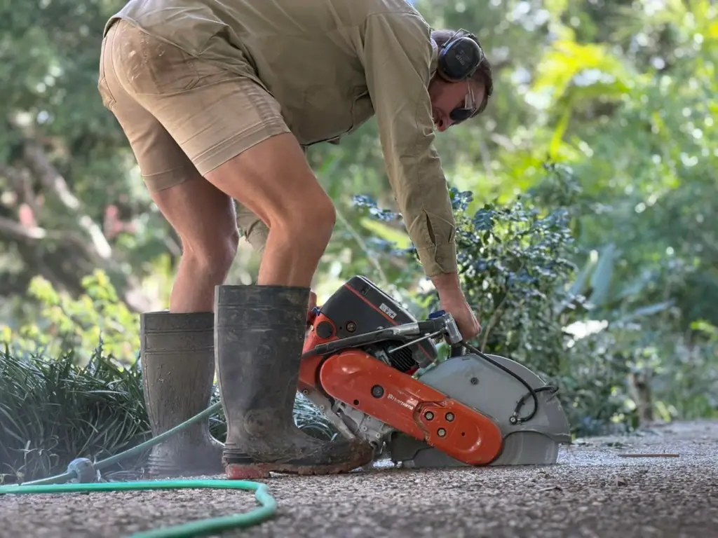 A Salt Landscaping crew member cutting stone on site