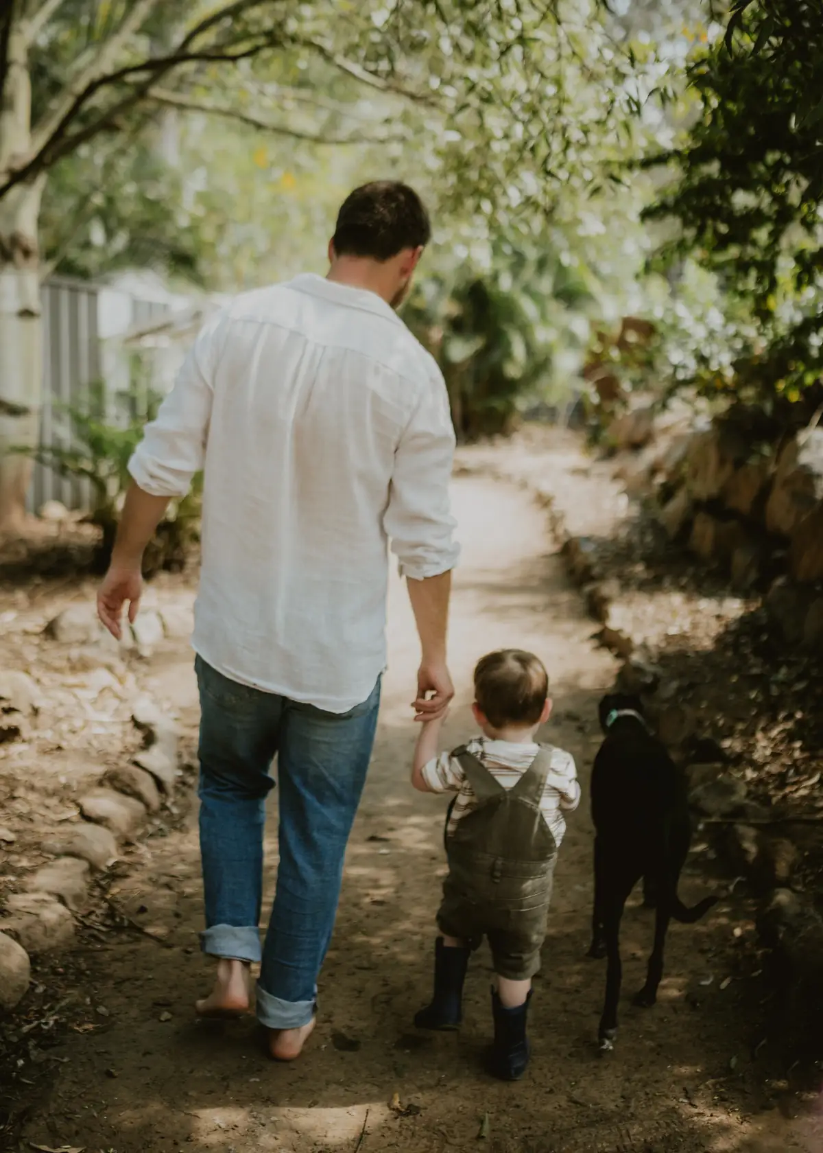 Salt owner Tim walking with his young son and dog along a bush path on his Karana Downs acreage property